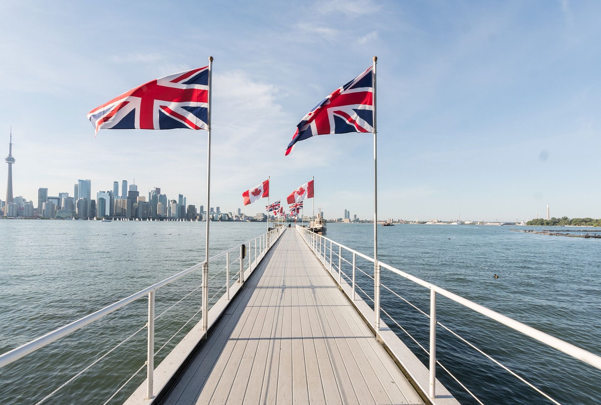 Dock with flags reaching out over the lake toward the Toronto skyline