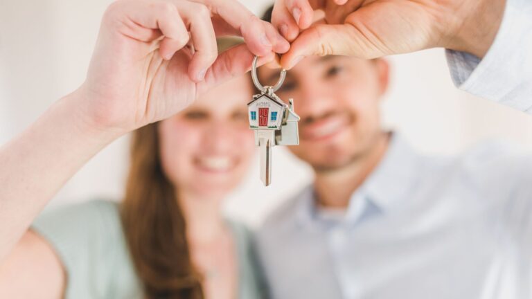 Smiling couple holding up a set of house keys
