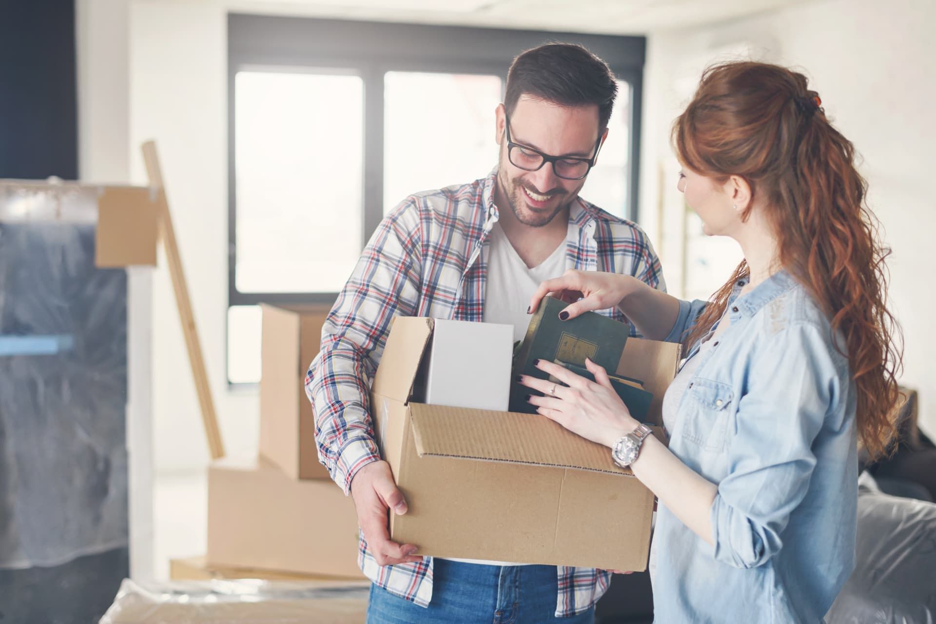 Couple unpacking a moving box in their new home